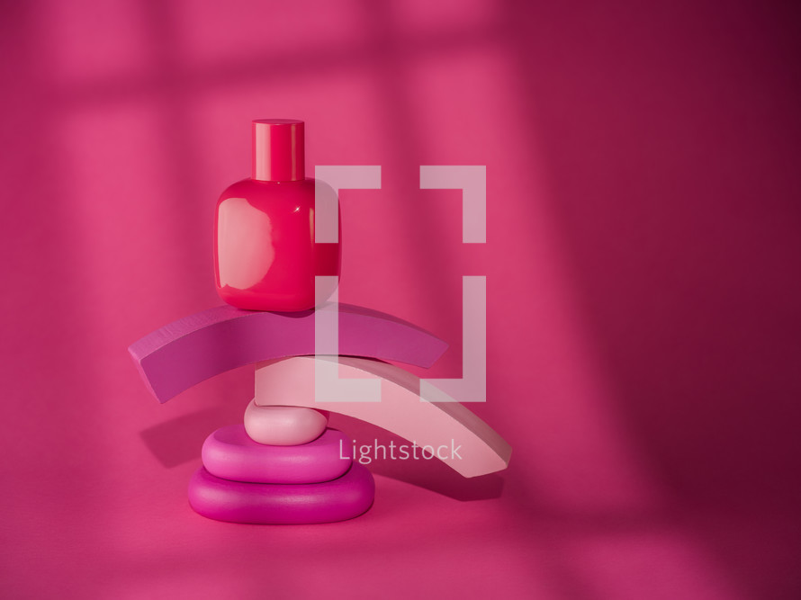 Pink bottle of cosmetic over pink background