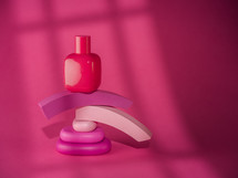 Pink bottle of cosmetic over pink background