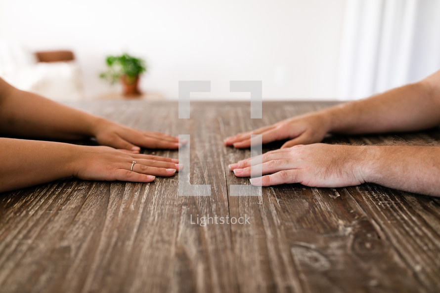 couple with hands on a kitchen table 