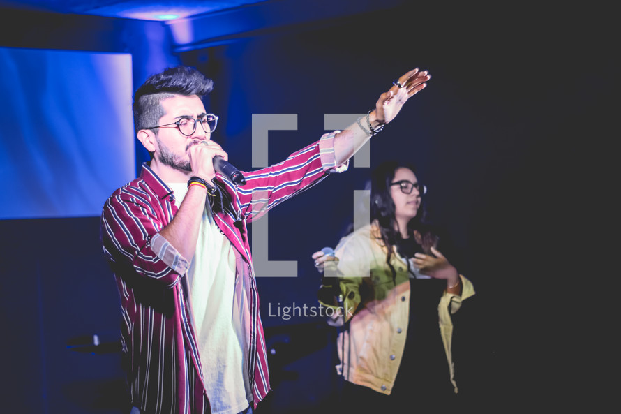 worship leader on stage holding a microphone 