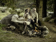 Couple making s'mores in campfire