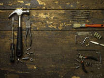 pliers, hammer, drill bits, wrench - tools on a wood background 