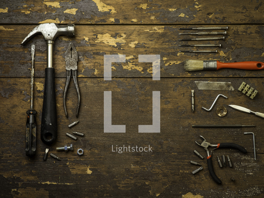 pliers, hammer, drill bits, wrench - tools on a wood background 