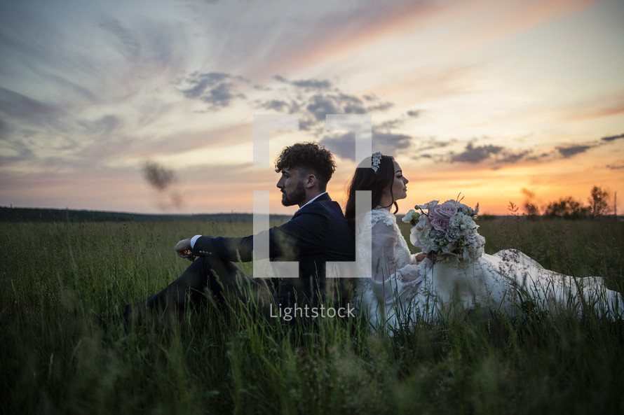 a bride and groom in a field 