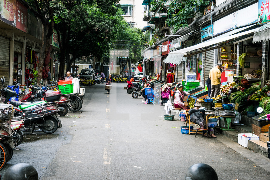 parked scooters and shops on a street in China 