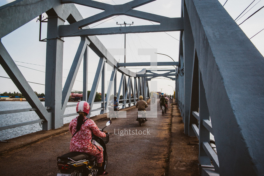 motorcycles crossing a bridge in Cambodia 
