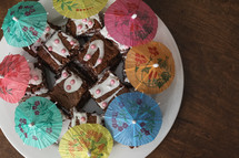 Child made platter of brownies with cocktail umbrellas 