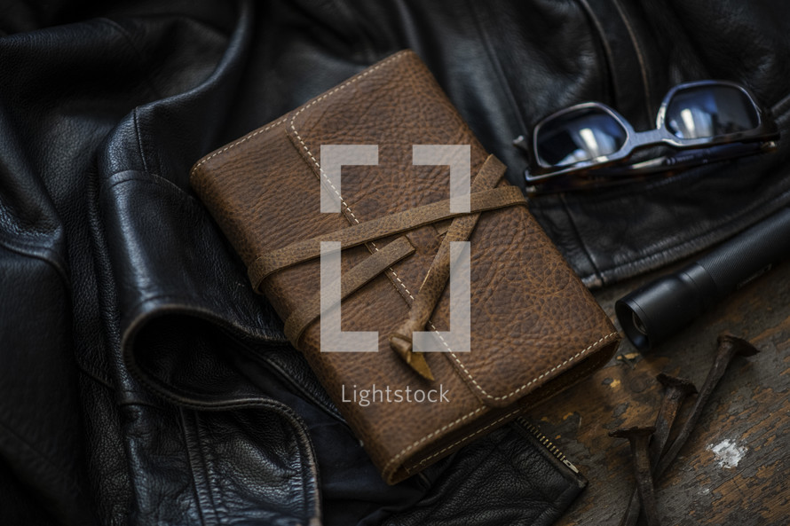 leather jacket, leather-bound Bible, and sunglasses 