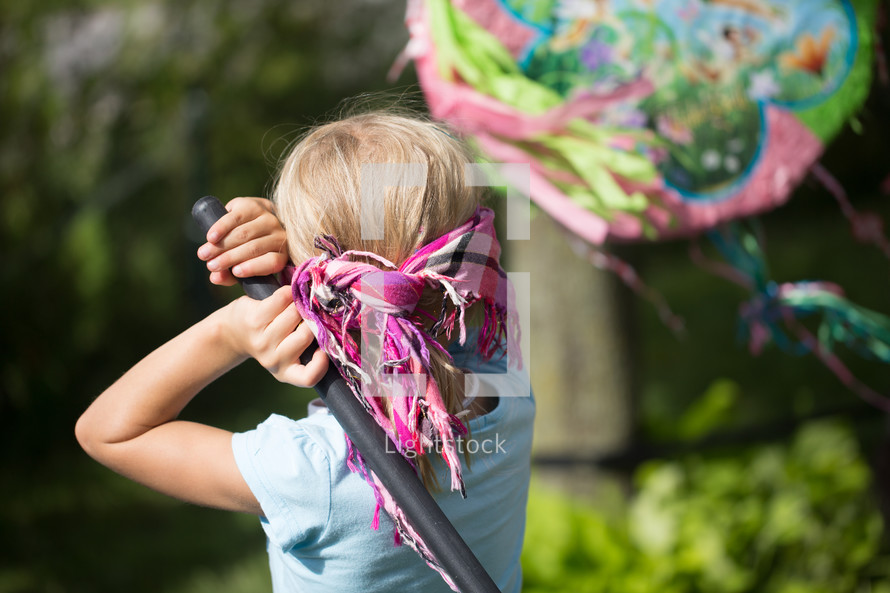 girl child hitting a piñata 