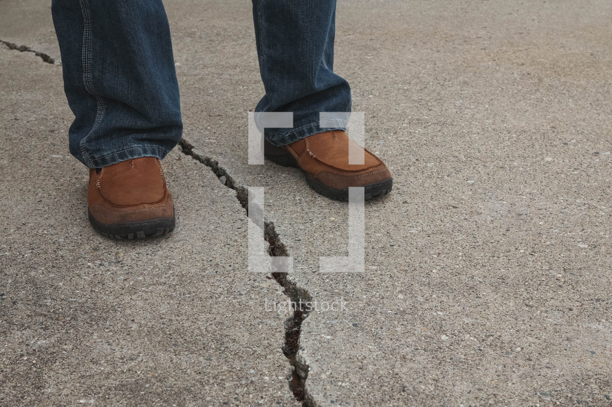 man standing with a crack between his feet