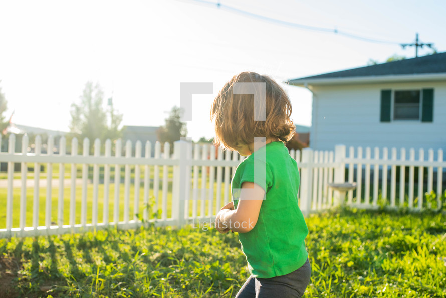 toddler girl running in a backyard 