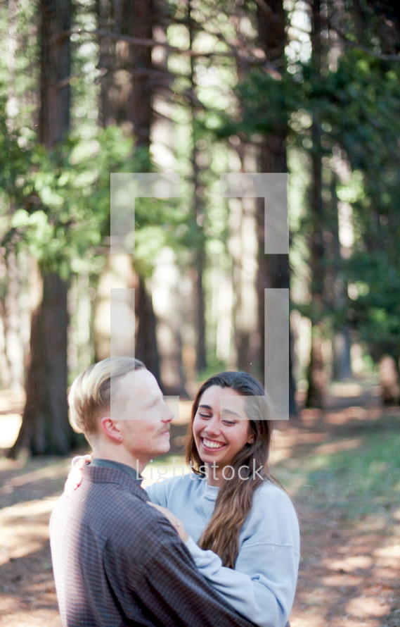 couple hugging in the woods 