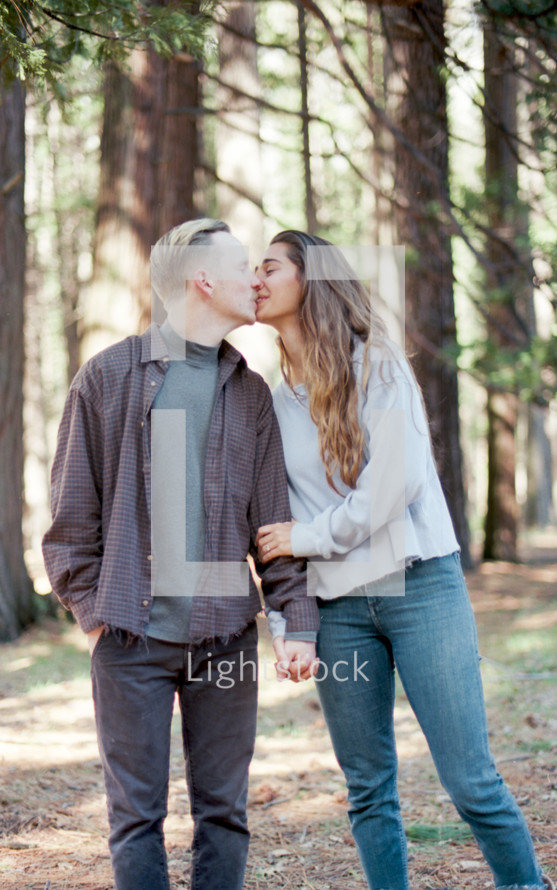 couple kissing in the woods 