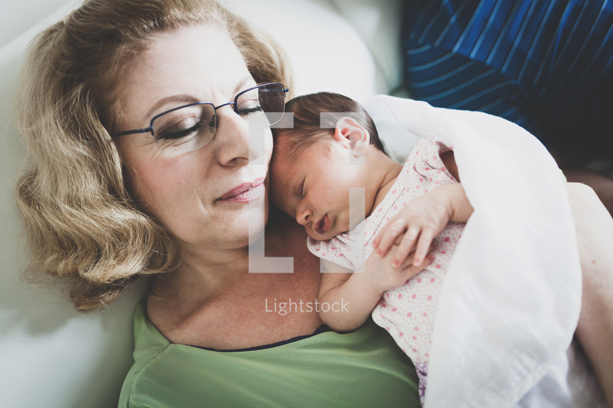 grandmother snuggling her newborn granddaughter 