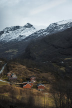 houses in a valley surrounded by snowy mountains 