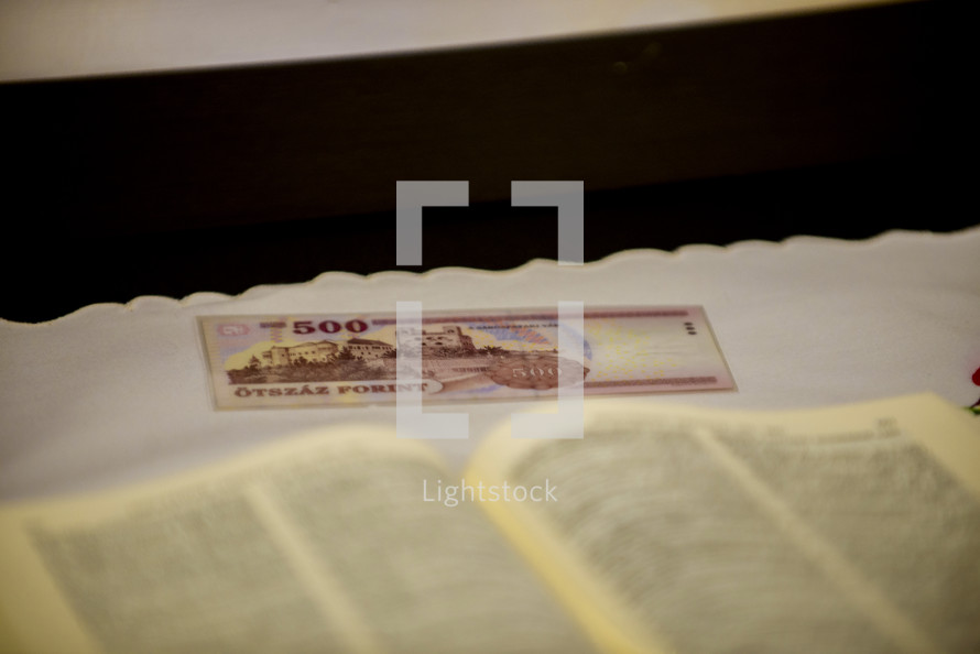 money and opened Bible 