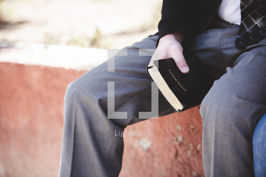 man sitting holding a Bible 