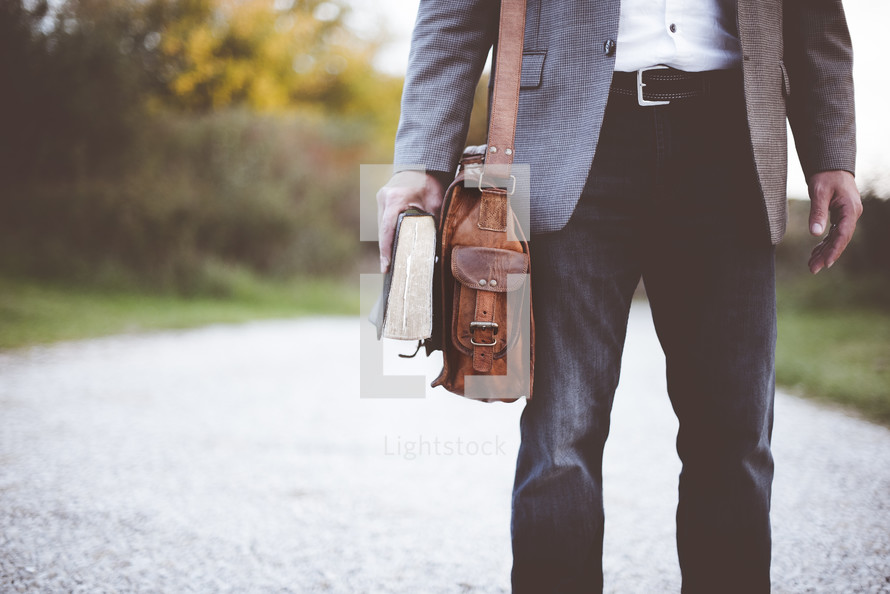 man holding a bag and Bible 