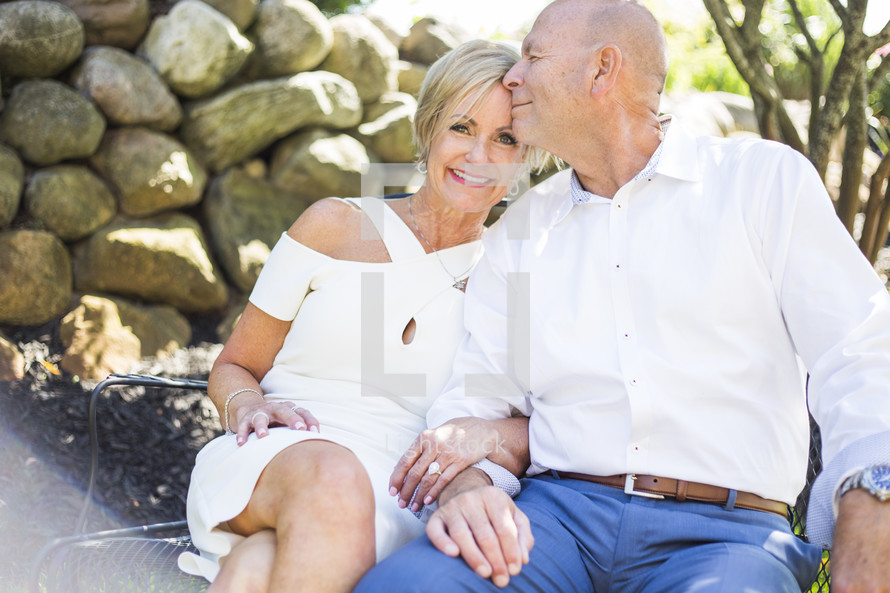 older couple sitting on a bench together 