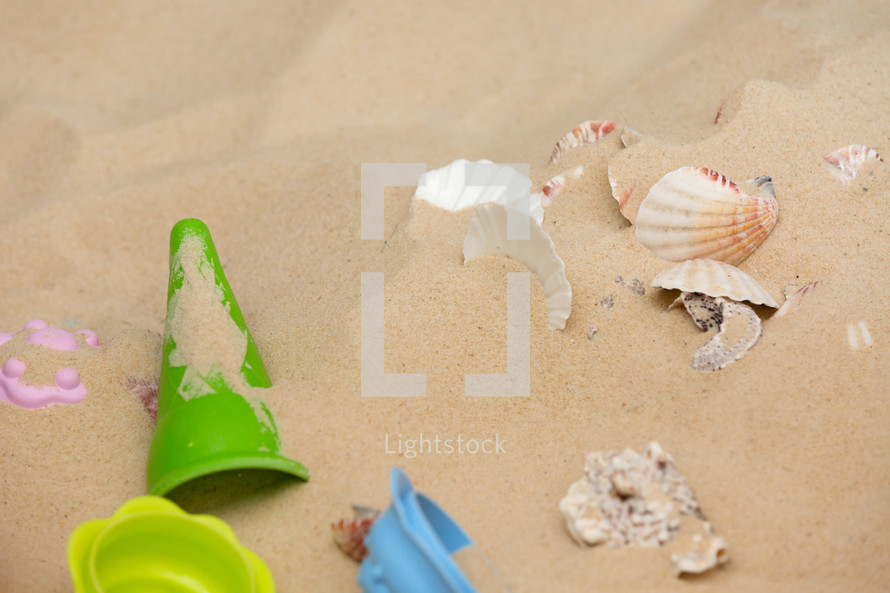 toys and shells in the sand 
