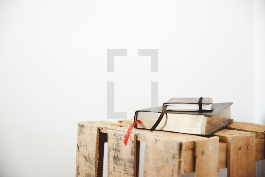 Bible and journal on a wooden crate 