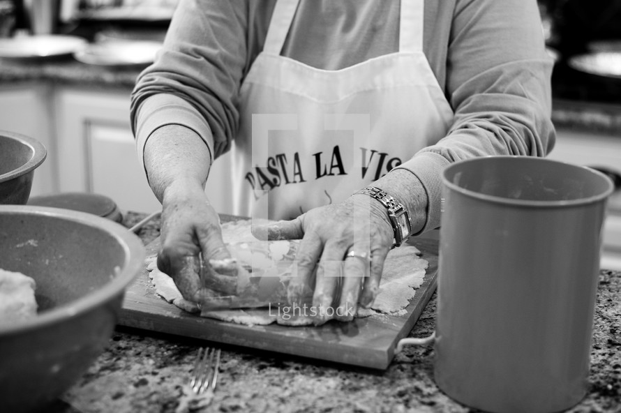 Mother with apron rolling out  pastries. 