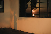 a sunset silhouette of a pregnant woman near the lake