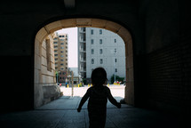 child running through a tunnel in a city in Japan 