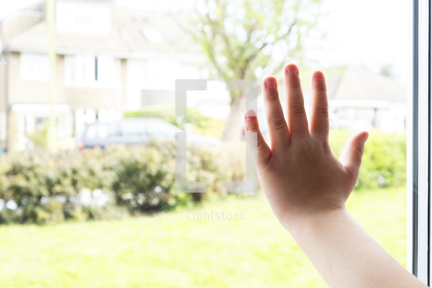 Boy holding hand on a window