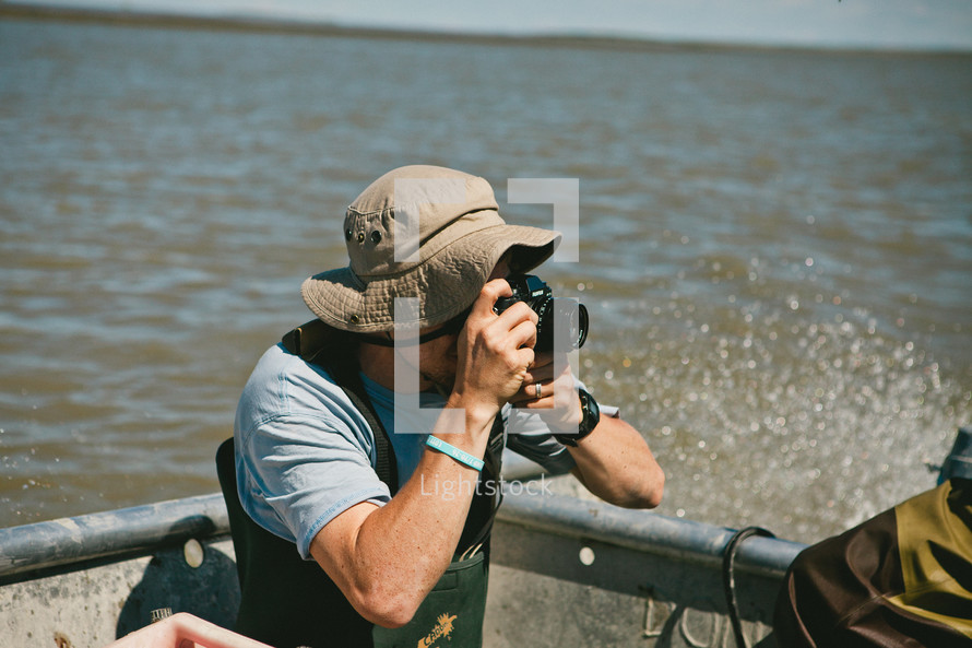 man taking a picture with a camera on a boat 