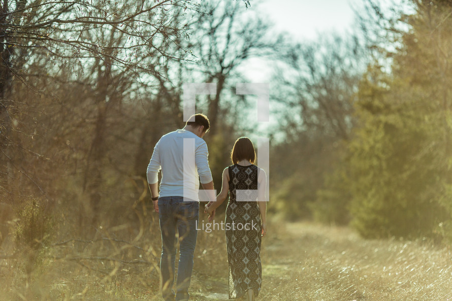 a couple walking outdoors holding hands 