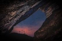 view of three crosses through crack in rocks 