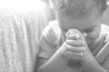 a toddler in prayer 