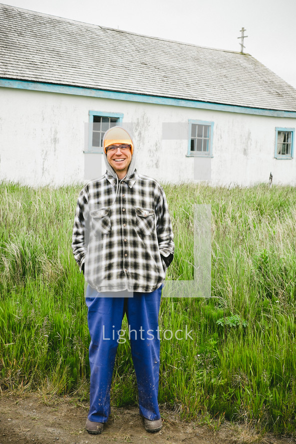 man bundled up in hoodie and cap standing outdoors in Alaska 