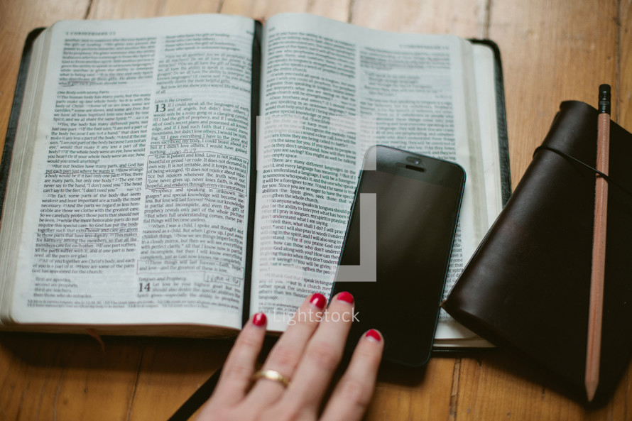 Open Bible, cellphone, and journal 