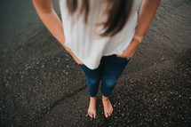 a woman standing barefoot on asphalt 