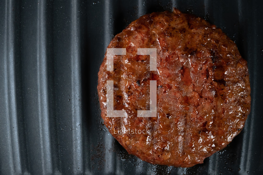 Process of roasting meat steak on barbecue grill plate. Cooking beef or pork patty. Raw cutlet for burger. Close-up shot. High quality photo