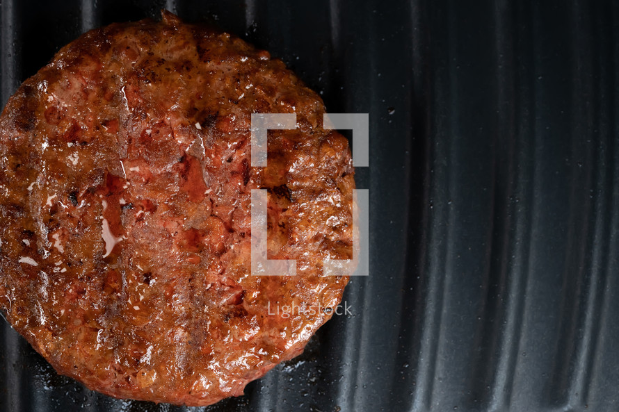 Process of roasting meat steak on barbecue grill plate. Cooking beef or pork patty. Raw cutlet for burger. Close-up shot. High quality photo