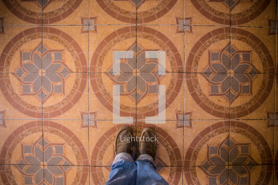 feet standing on pattern tiles 