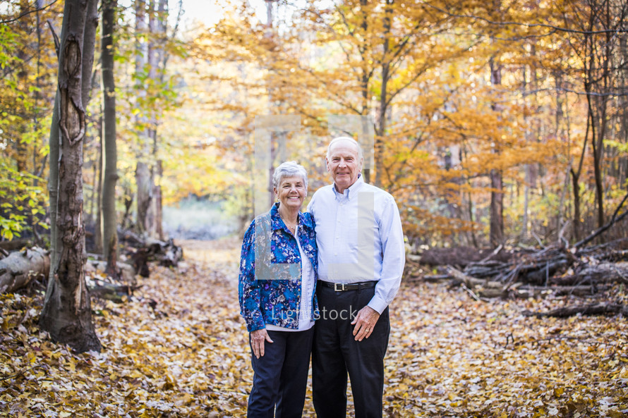 an elderly couple standing outdoors in fall 