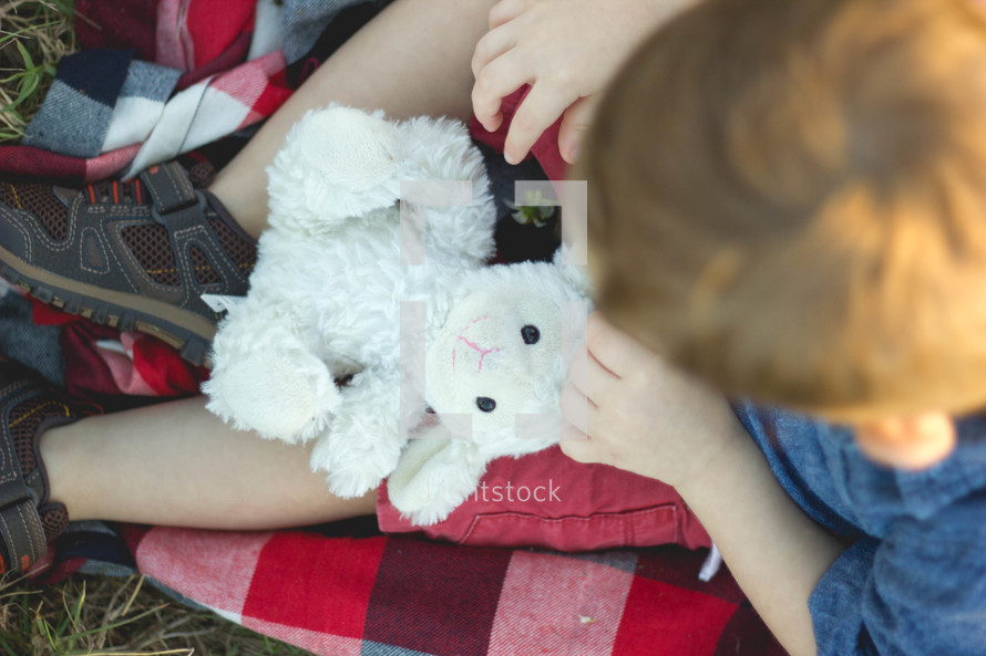 a child holding a stuffed animal in his lap 