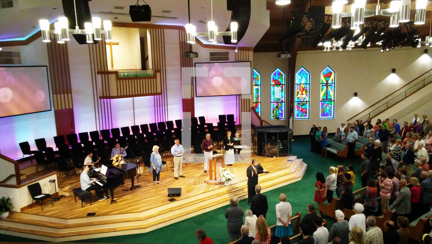 A Sunday morning traditional church worship service with musicians, singers and pastor leading the church in morning worship.  