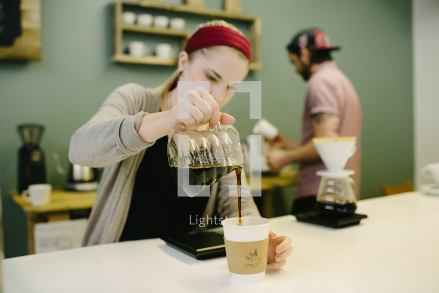 barista brewing coffee behind the counter 