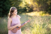 teen girl playing a ukulele 