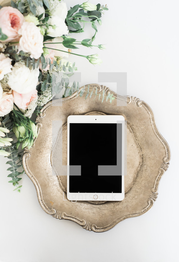 iPad on a silver tray and bouquet of flowers 