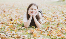portrait of a girl lying in fall leaves 