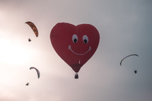 heart shaped hot air balloon and parachuters 