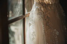 a wedding dress leaning against a window