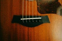 Bridge and strings of a guitar.