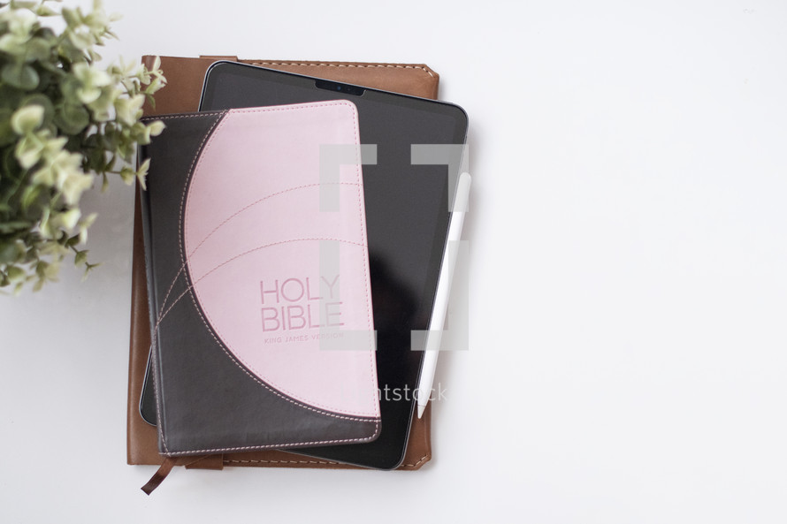 Holy Bible, tablet, and notebook 